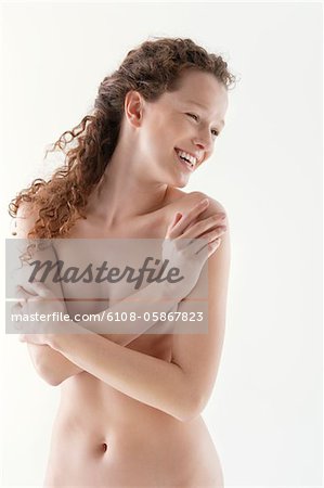 Naked woman hugging herself and smiling