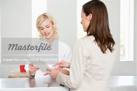 Frau mit weiblichen Krankenschwester untersuchen einen ärztlichen Bericht