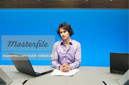 Businessman at a conference table with a laptop