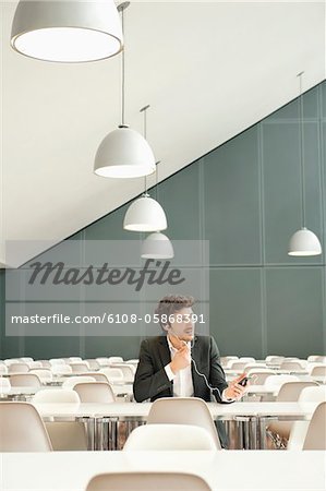 Businessman sitting at a cafeteria and talking on a mobile phone