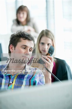 Businessman holding telephone receiver and looking angry