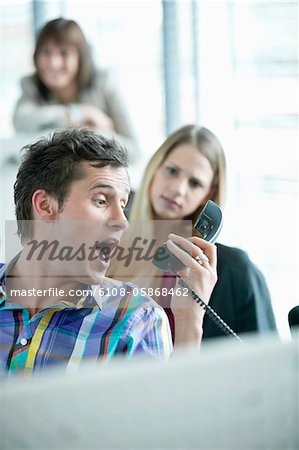 Businessman holding telephone receiver and shouting