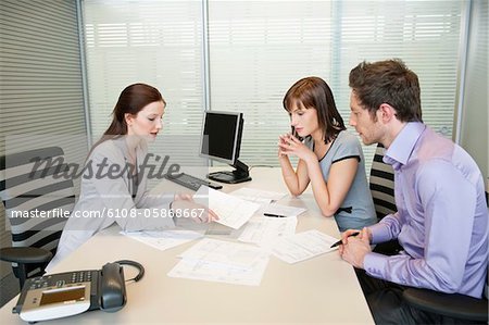 Weibliche Immobilienmakler eine Broschüre, ein paar anzeigen Weibliche Immobilienmakler eine Broschüre, ein paar anzeigen