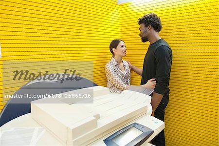 Business couple romancing near a photocopy machine