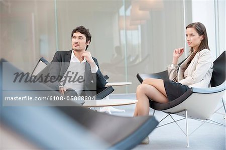 Dirigeants d'entreprises assis sur une chaise dans une salle d'attente