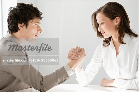 Businessman arm wrestling with a businesswoman