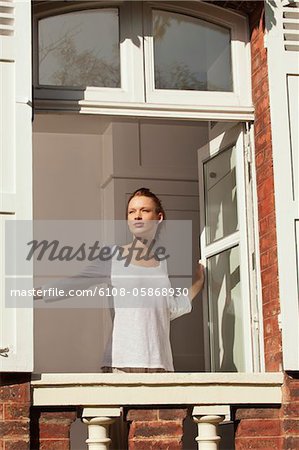 Young woman opening window