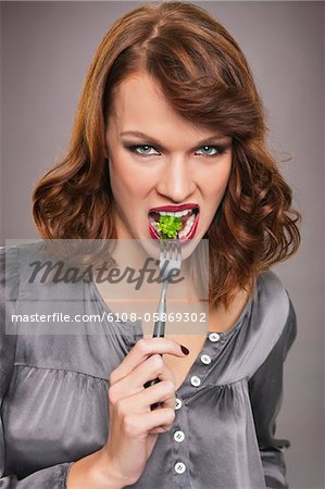 Jeune femme mangeant brocoli