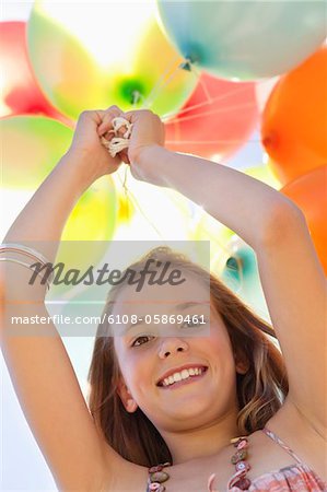 Portrait of a girl playing with balloons and smiling