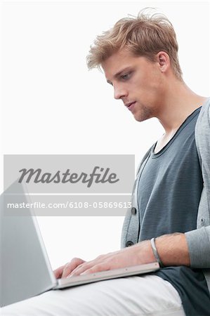 Jeune homme à l'aide d'un ordinateur portable