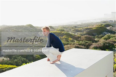 Junger Mann, die Aussicht von der Terrasse eines Hauses betrachten