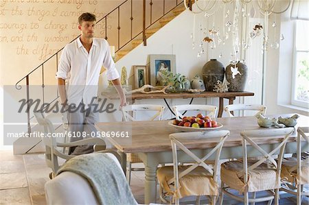 Homme debout de la table à manger avec la main dans la poche