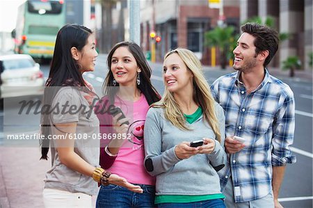 Friends using mobile phones outdoors