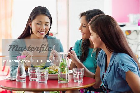 Three women eating food in a restaurant