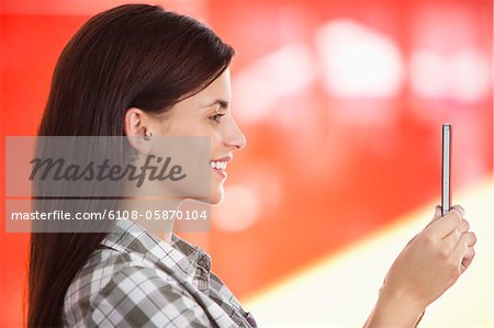 Jeune femme de prendre une photo d'elle avec un téléphone mobile