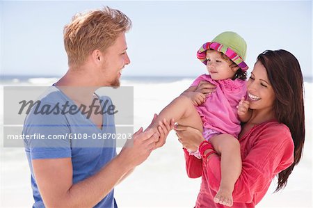 Couple enjoying on the beach with their daughter