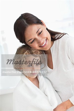 Portrait of a woman hugging her daughter wrapped in towel