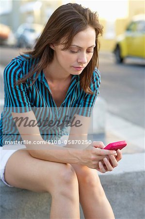 Young woman text messaging with a mobile phone