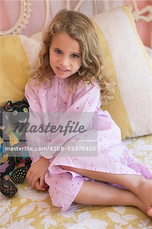 Portrait d'une petite fille assise sur le lit