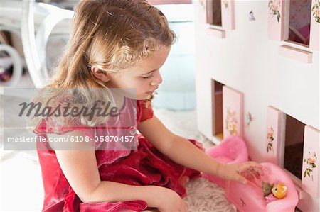 Adorable petite fille joue à la poupée