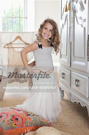 Portrait of a little girl dressed like her mother in oversized