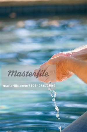 Gros plan de la main de l'homme, un contact avec l'eau de la piscine