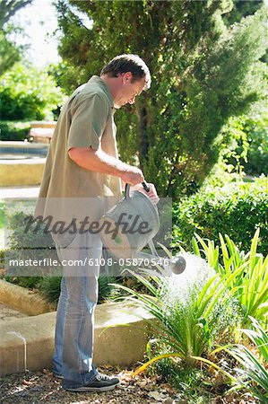 Seitenansicht eines Reifen Mannes, die Bewässerung von Pflanzen in einem Garten