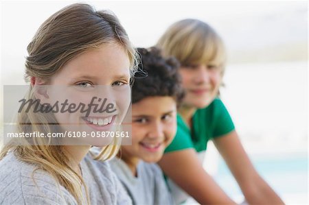 Portrait d'une jeune fille souriante avec ses deux frères