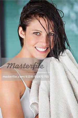 Portrait of a woman drying her hair with a towel