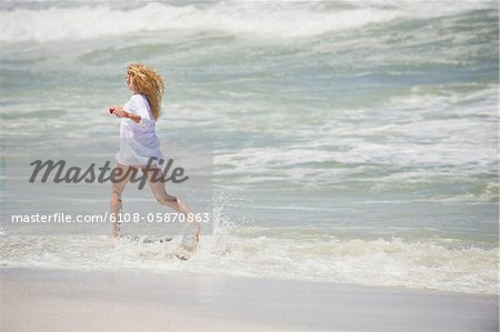 Seitenansicht einer Frau am Strand laufen