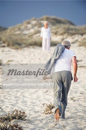 Vue arrière d'un homme senior courir vers une femme debout dans le fond