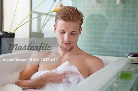 Man having bubble bath in a bathtub