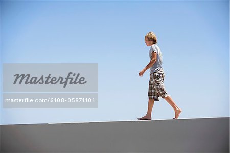 Teenage boy walking on the edge of a terrace