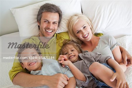 Paar mit ihren Kindern im Bett entspannen