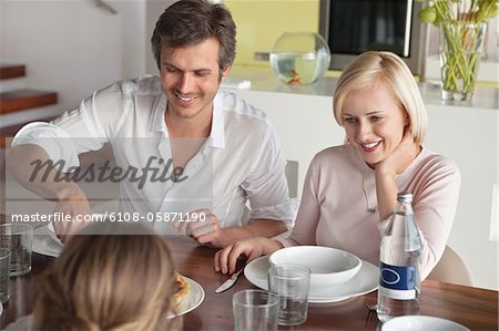 Couple having food with their daughter