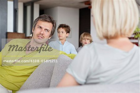Paar Gespräch während Kinder im Hintergrund stehend