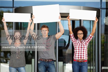 Trois amis pour protester avec des plaques-étiquettes vierges