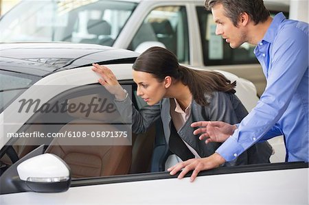 Couple examining a car before buying
