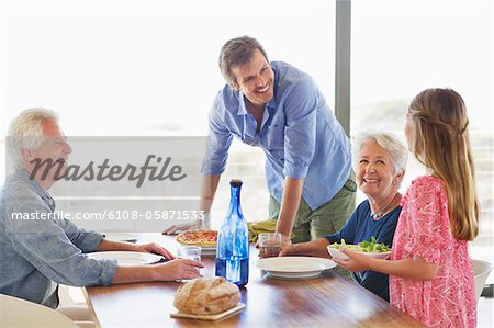 Multi generation family eating food at a dining table