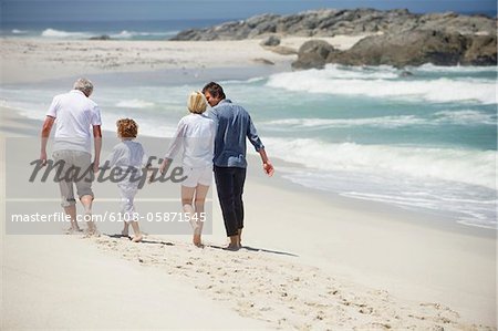 Rear view of a multi generation family walking on the beach