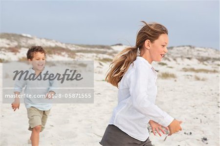 Junge mit seiner Schwester spielen, am Strand