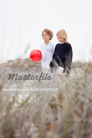 Garçon et fille marcher ensemble sur fond de ciel clair