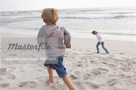 Vue arrière d'un garçon sur la plage avec sa sœur