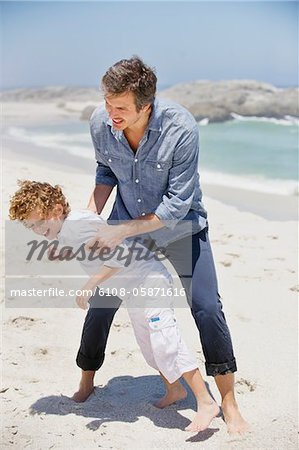 Man playing with his son on the beach