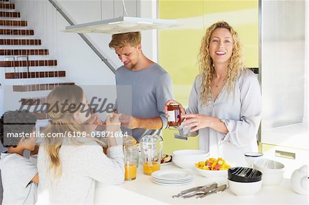 Ehepaar mit zwei Kindern in einer Küche Essen zubereiten