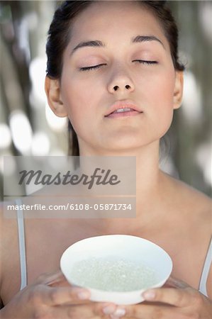 Beautiful young woman holding a bowl with bath salt