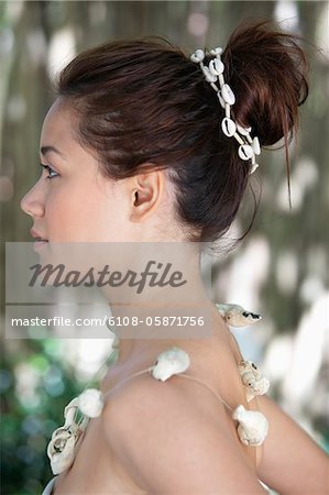 Side profile of a beautiful young woman wearing a shell necklace