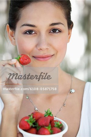 Portrait d'une jeune femme tenant un bol de fraises