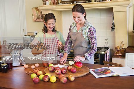 Senior woman and her daughter cooking food in kitchen