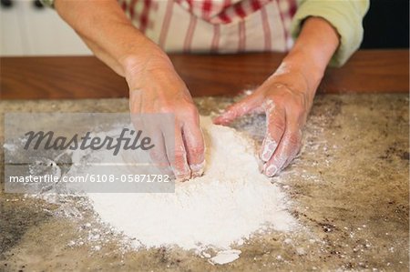 Close-up of a senior woman's hand mixing flour